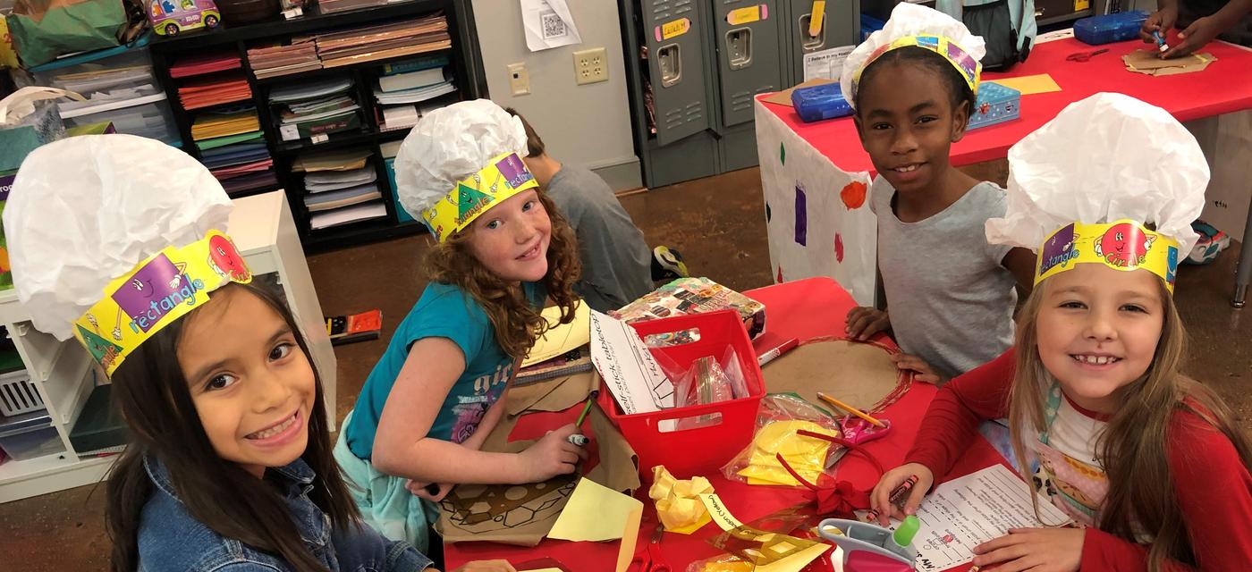four girls wearing chef hats learning while getting crafty