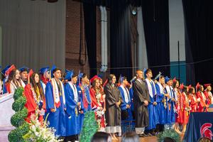Graduates standing on stage, facing the audience