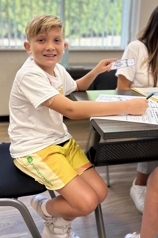 a boy holding up a piece of paper