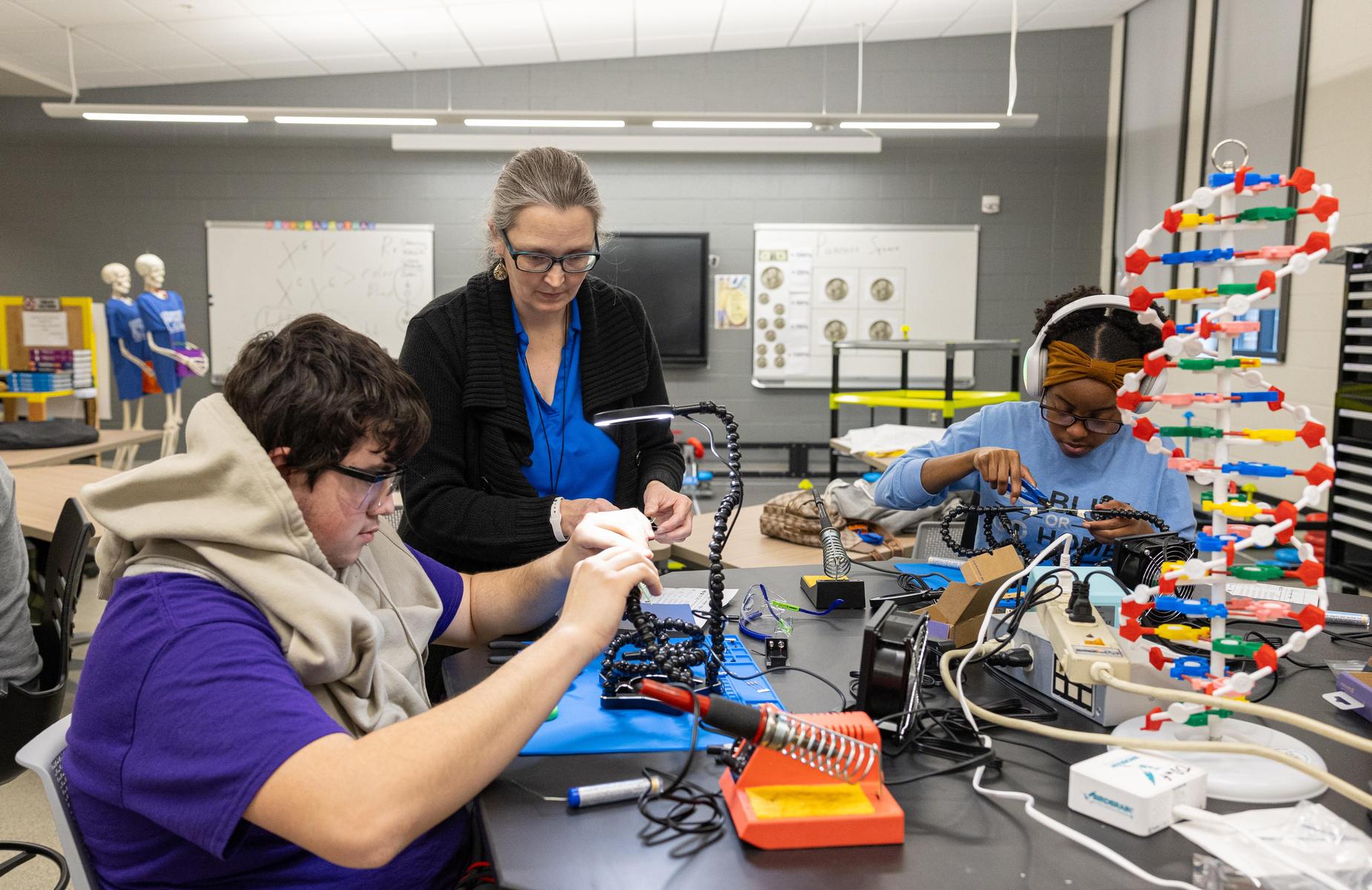 Students working on projects together in a modern classroom with various tools and materials.