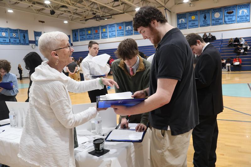 Student gets some financial information from a volunteer at Reality Fair