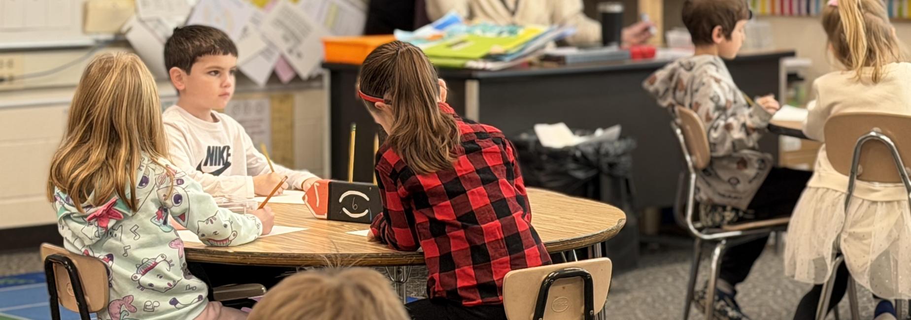 Students engaged in a classroom activity around a circular table.