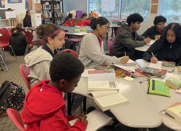 Students sit in groups to discuss books