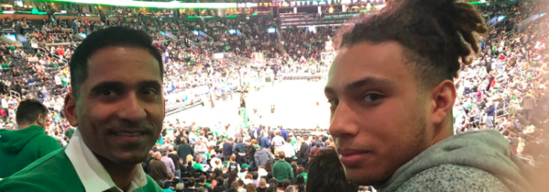 Student poses with mentor at basketball game