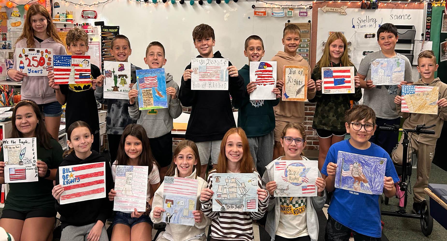 Students proudly holding their artwork featuring American flags and patriotic themes.