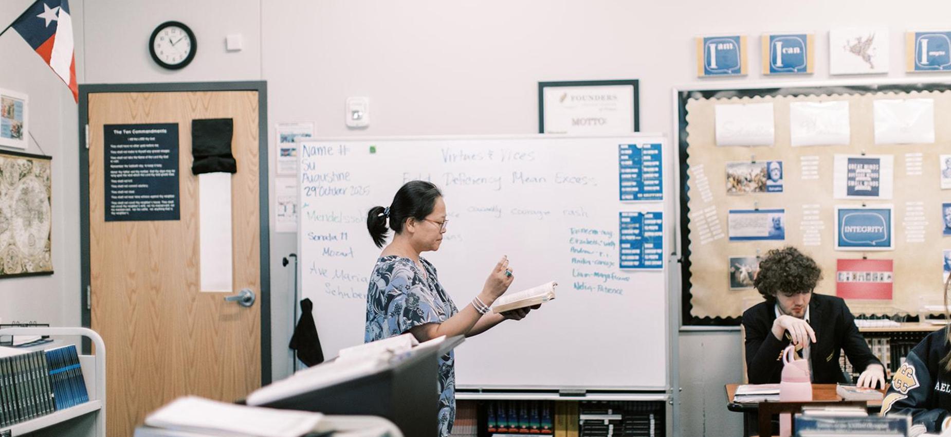 Teacher points to the whiteboard during a lesson