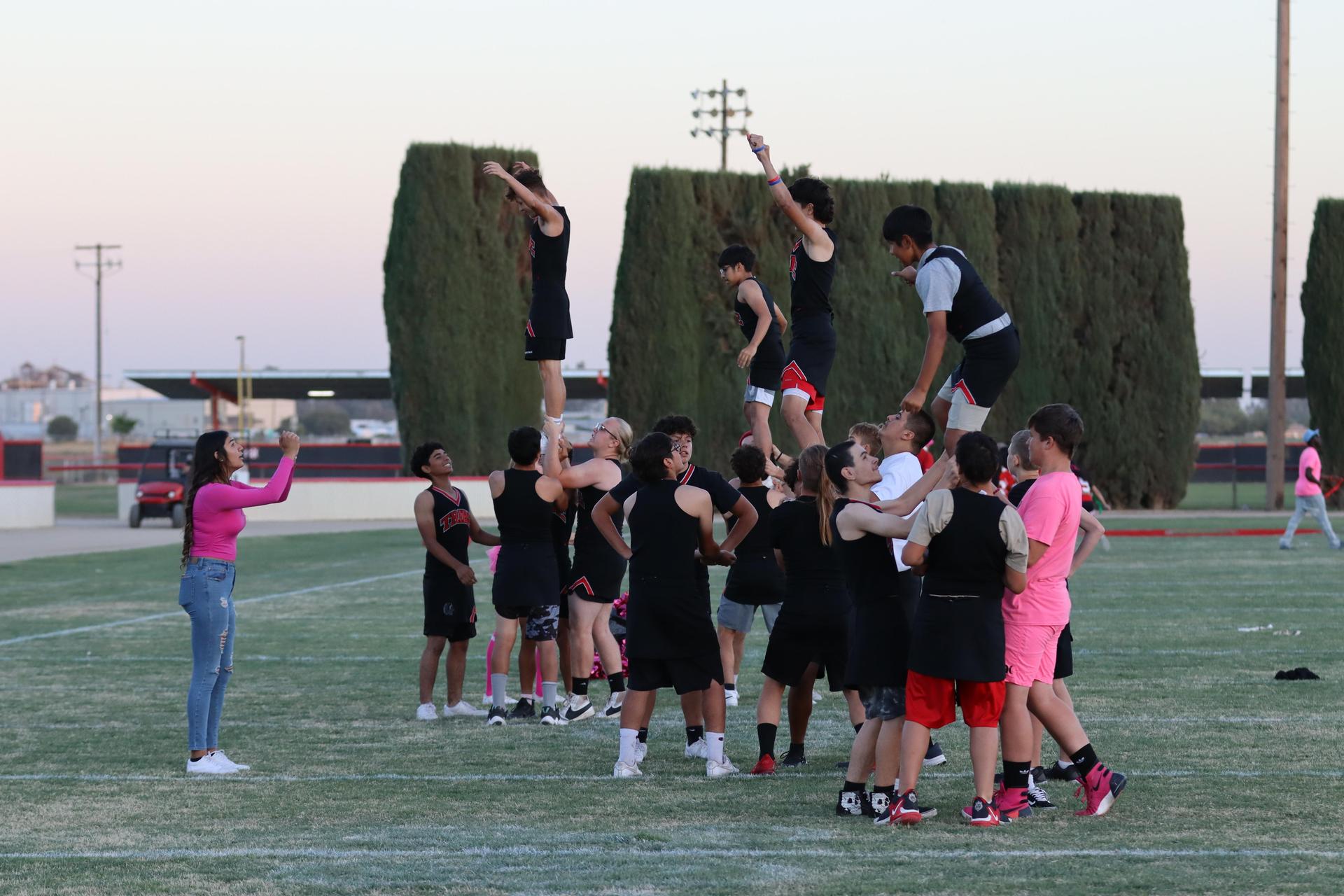 players, cheerleaders, and officials preparing for the powderpuff football game