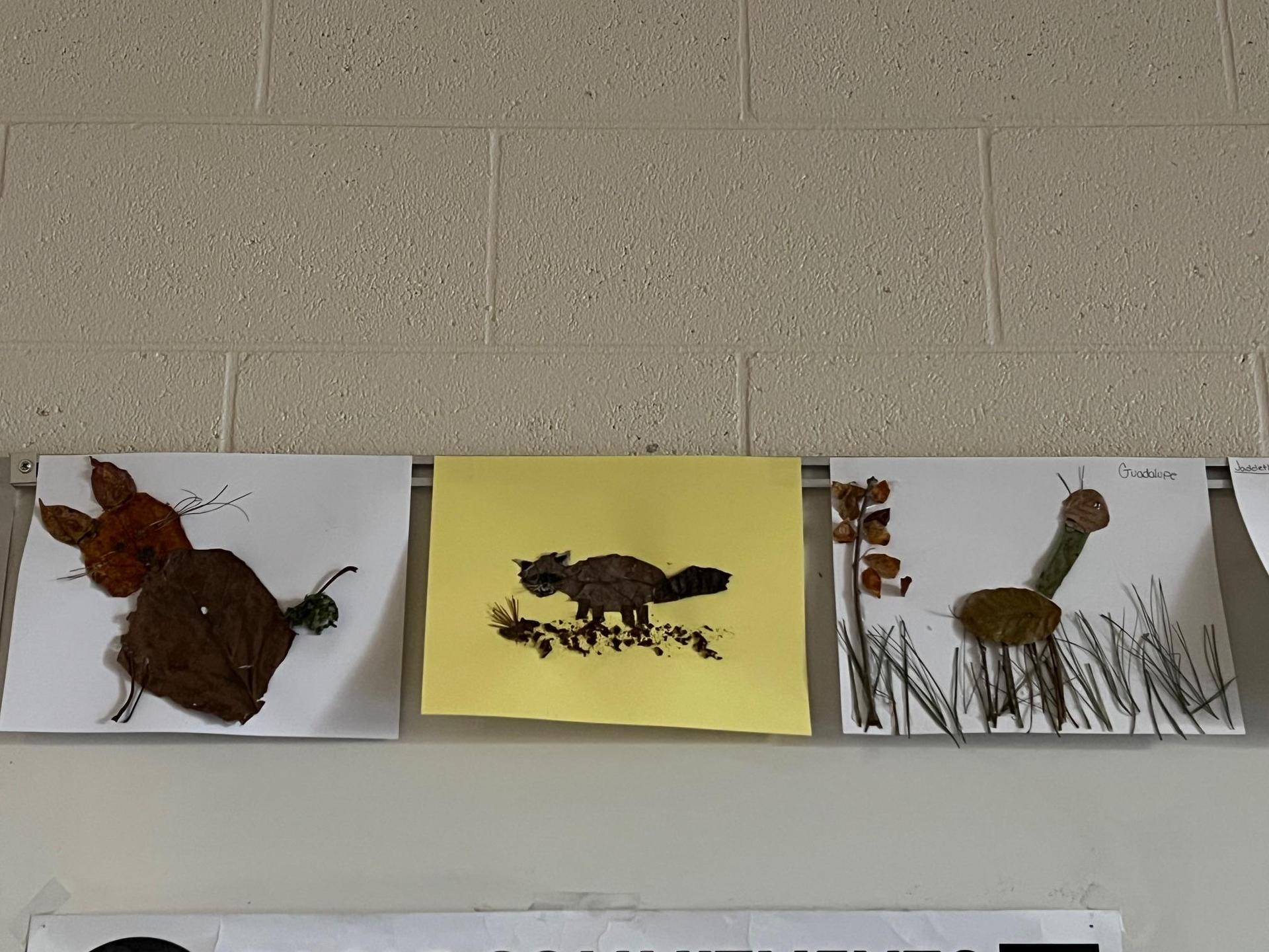 Three leaf art pieces of a bunny, raccoon, and caterpillar on white paper with a yellow background.