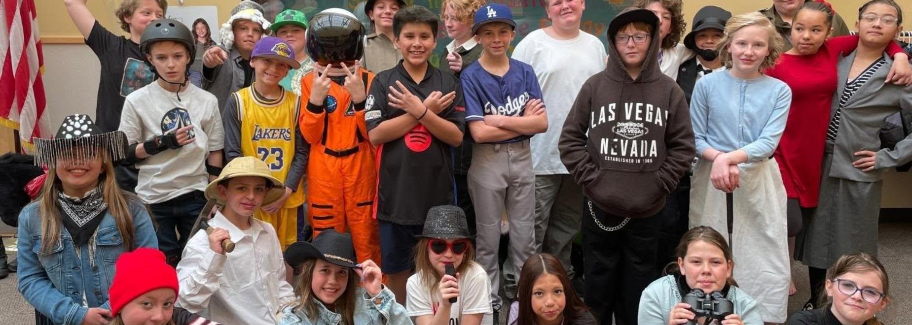 Large group of students in costumes posing together for a photo.