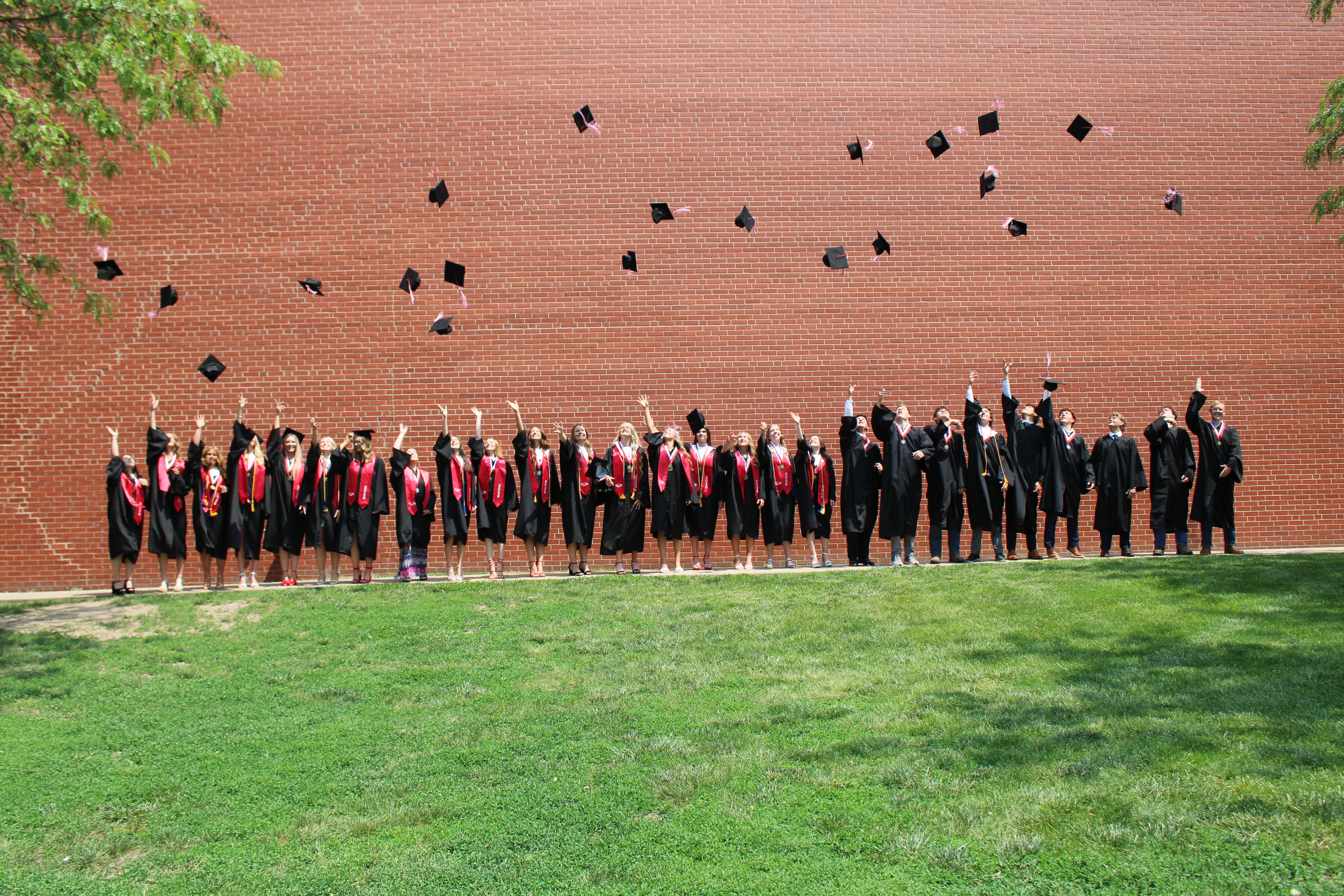 Graduating Senior of 2026 tossing their hats in the air.
