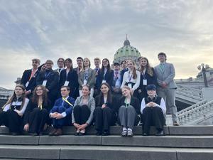 students dressed up sitting on steps outside of capital building