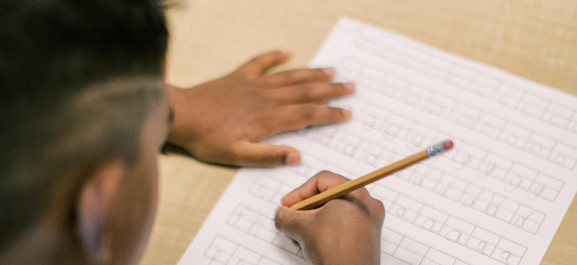 Student practicing handwriting on lined paper
