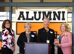 Sandi (Stager) Wake, (right), accepts the Distinguished Alumni Award from TKAA members.