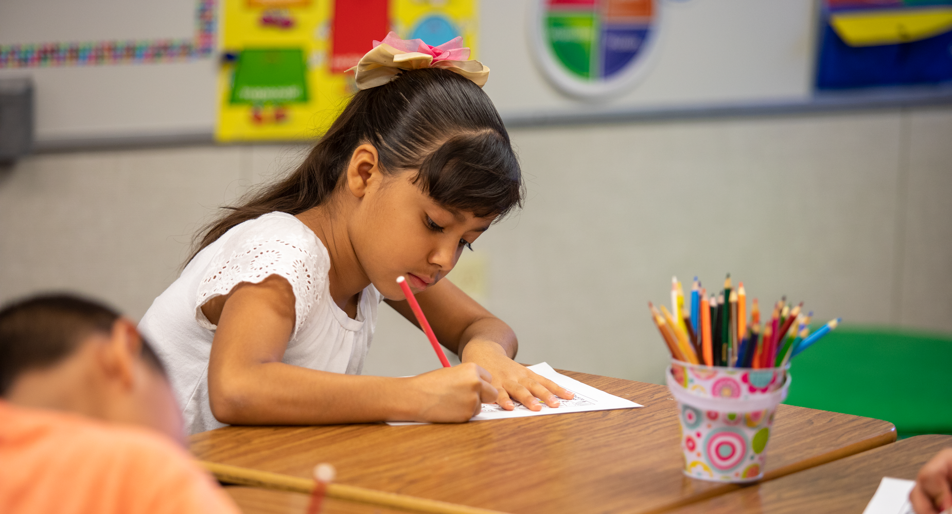 Girl at school desk coloring