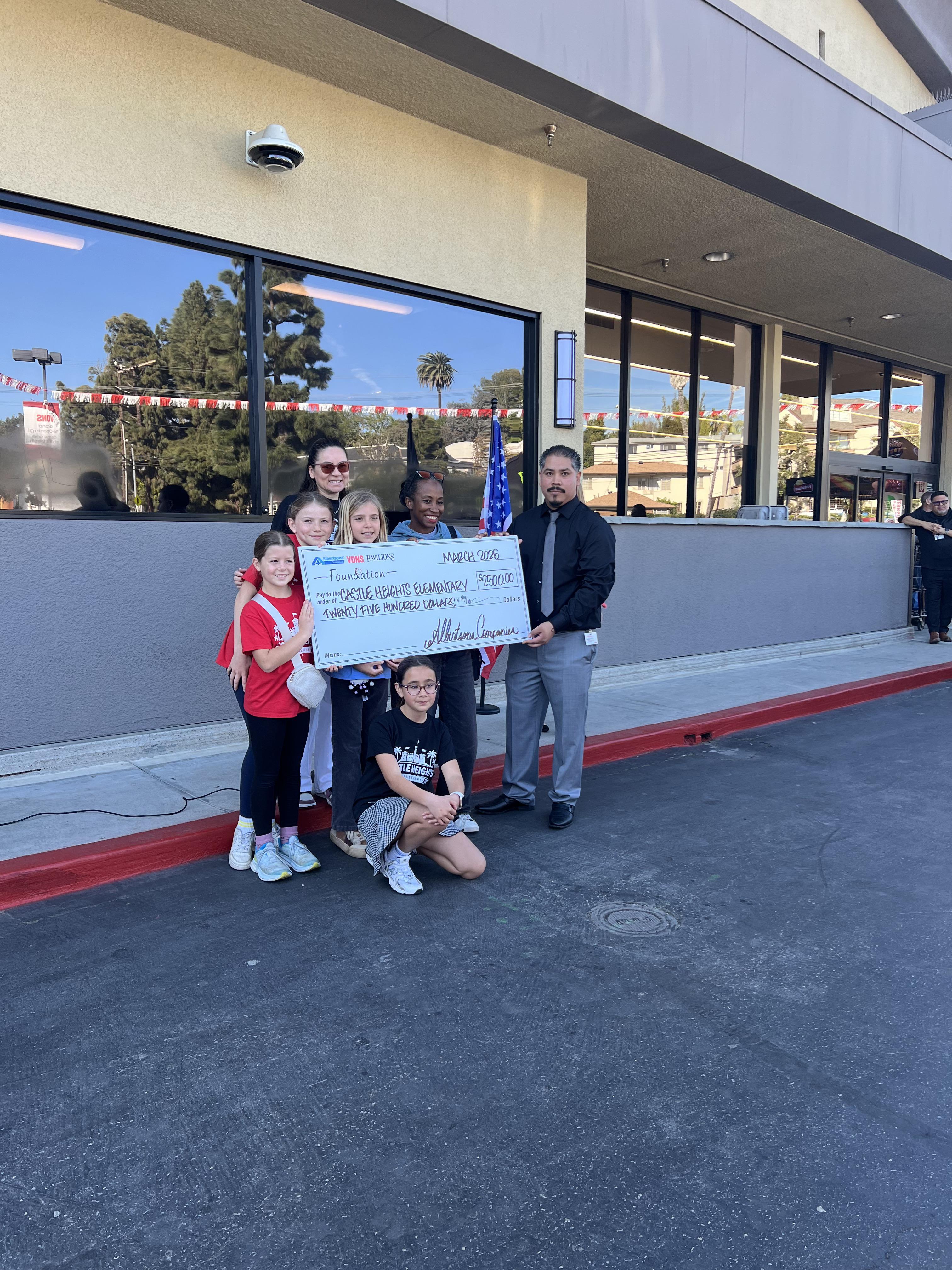Students with a large $2,500 donation check