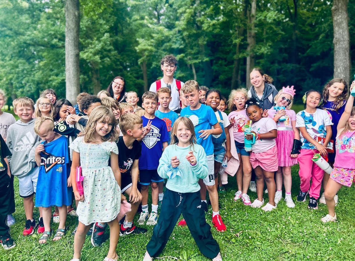 photo with kids outside with bright colors doing a color run at summer camp
