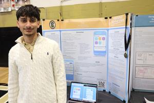 Student standing by their senior project