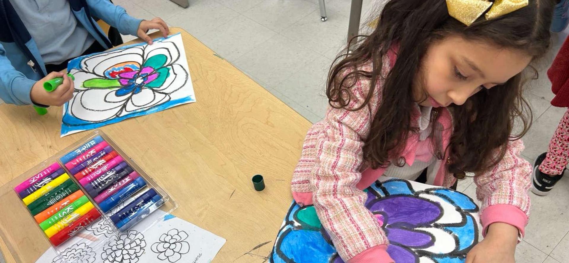 Children coloring on paper with vibrant markers in a classroom setting.