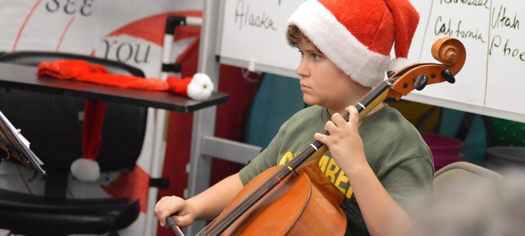 boy in Santa hat plays the cello