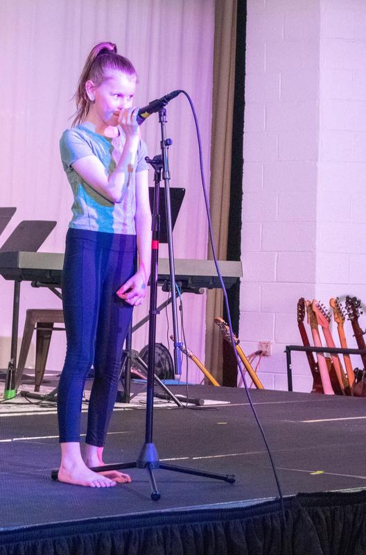 Lower schooler singing during the talent show