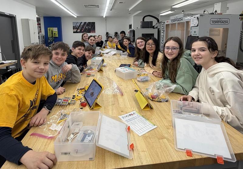 A large group of students sitting around a long table
