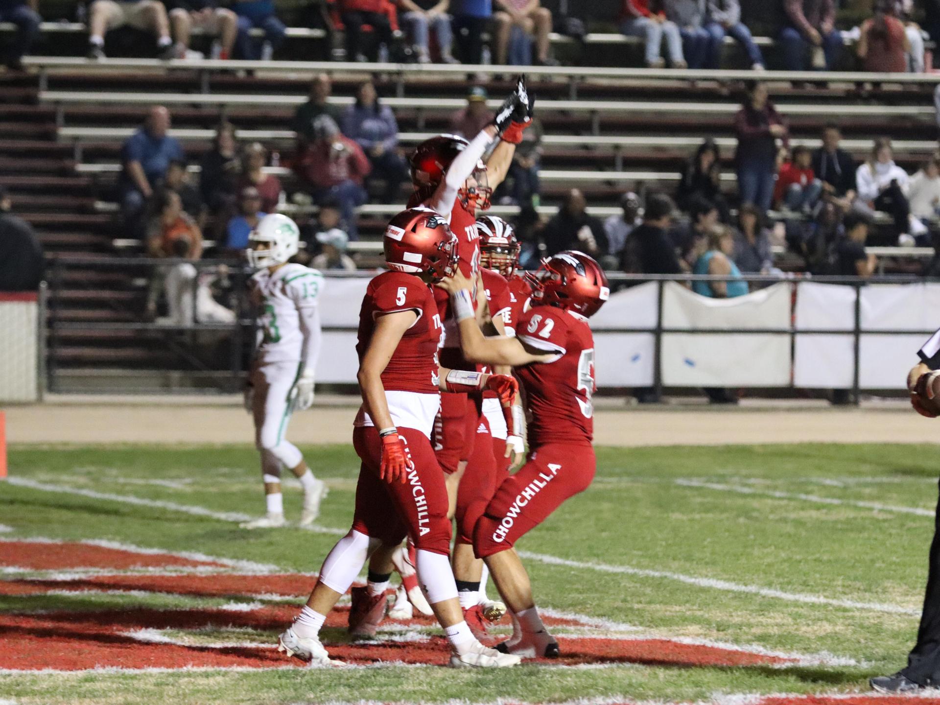 varsity football players in action against Riverdale