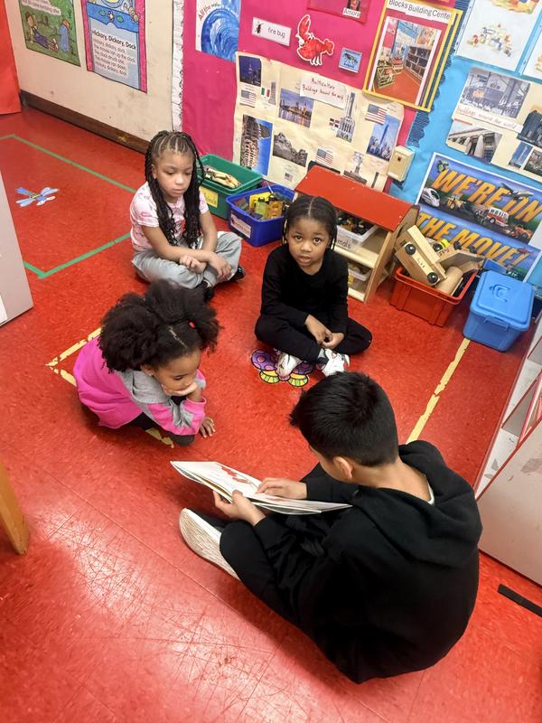 Student pointing and reading to students