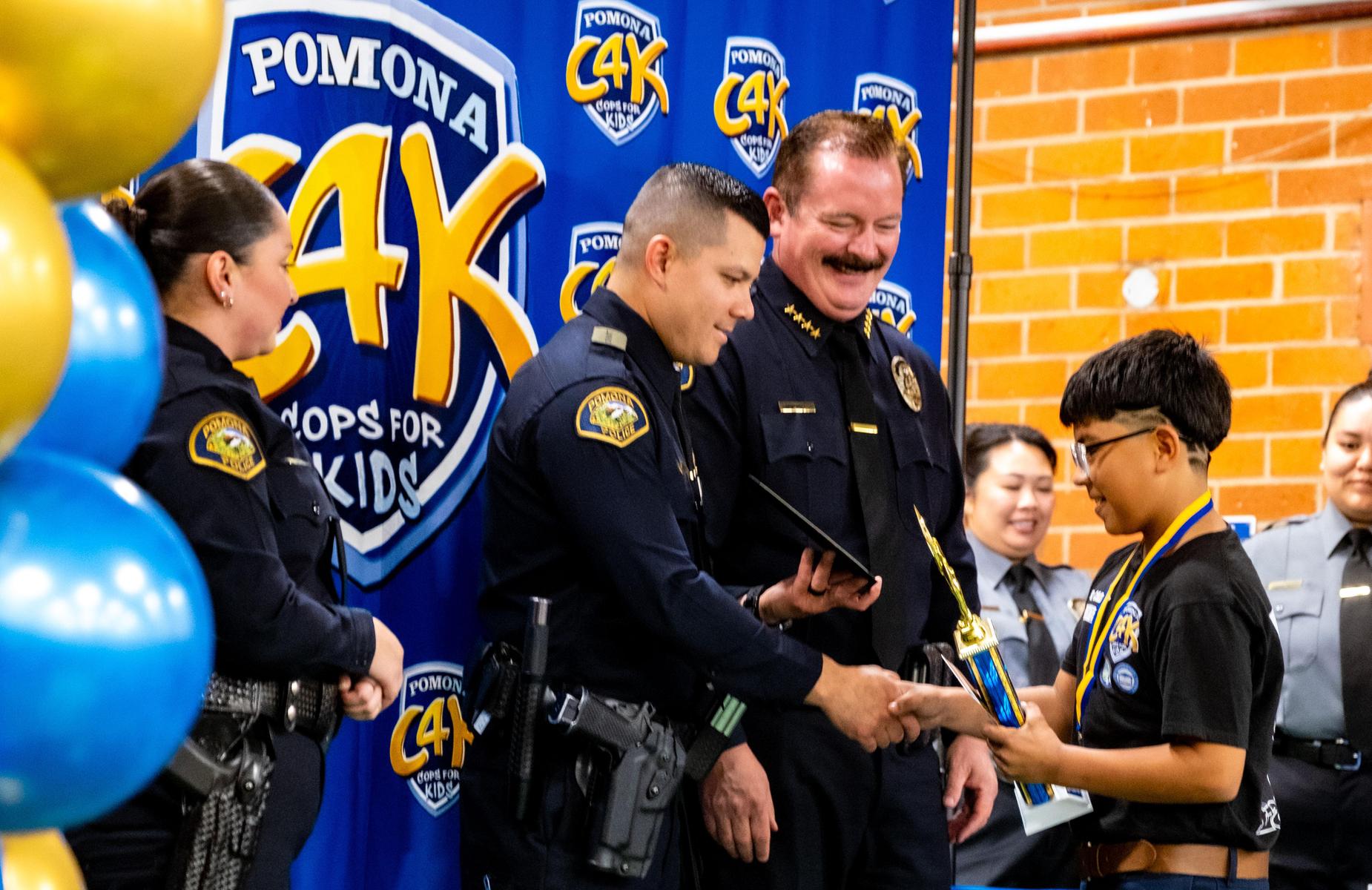 student receives award from police officers
