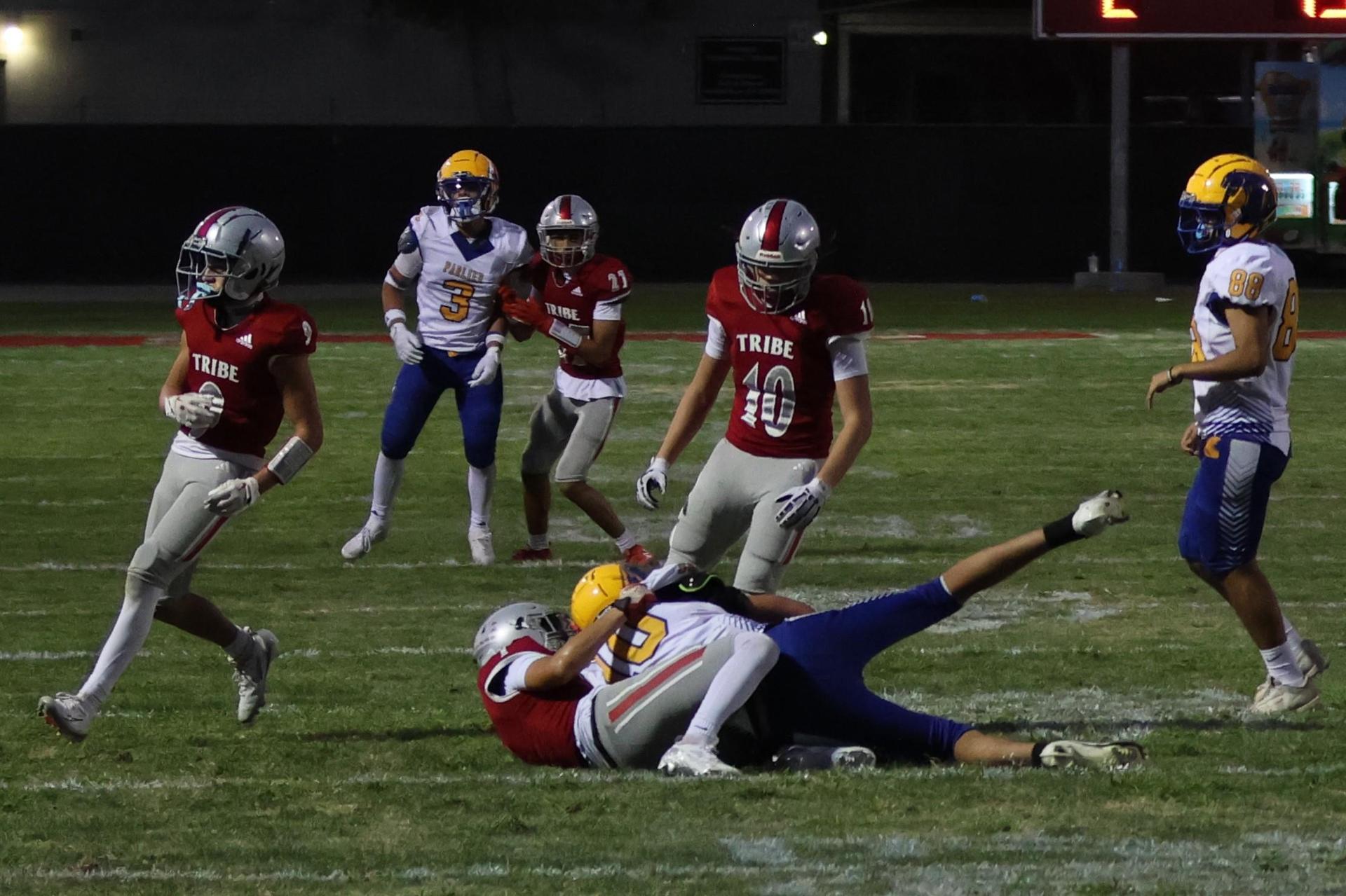 Varsity football players in action against Parlier 8