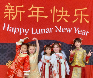 Happy Lunar New Year in English and Chinese with students dressed in traditional celebratory outfits