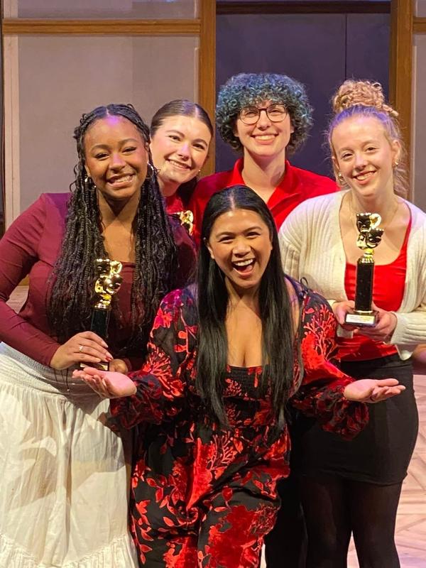 Performers pose with the host