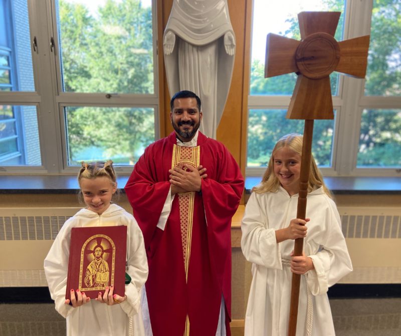 Father John Paul and servers pose for a photo before Mass.