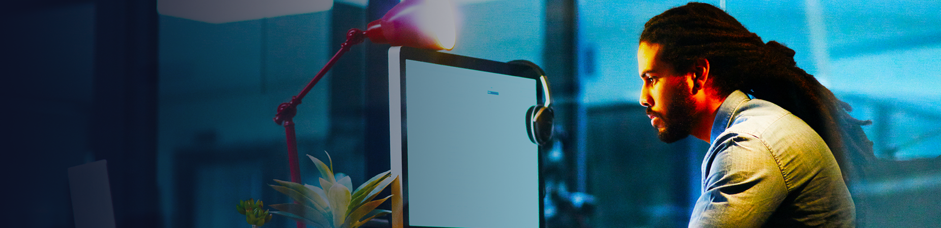 A person in a darkened room interacting with a computer.