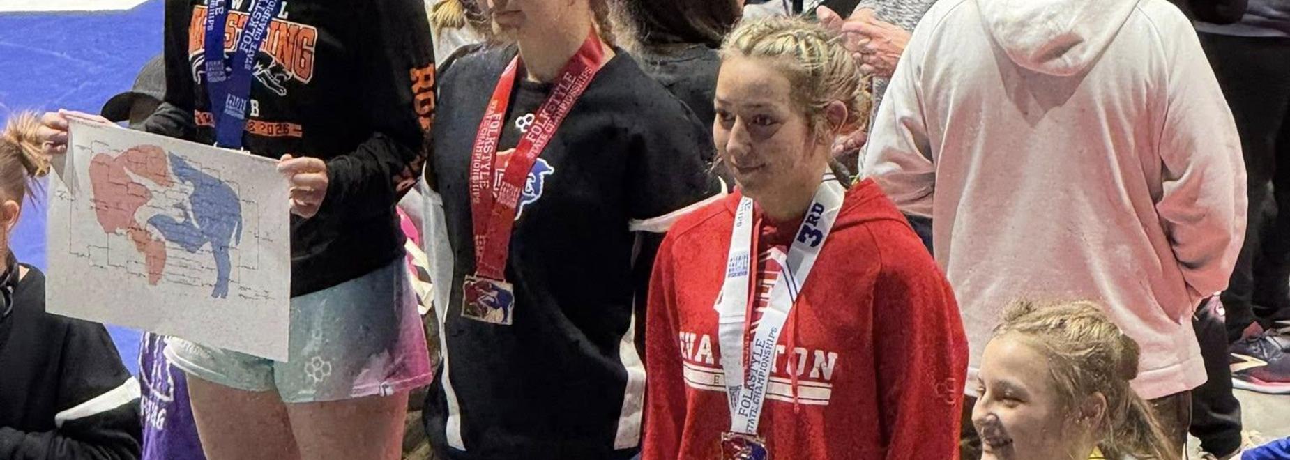 Three children on a podium holding medals and celebrating achievements.