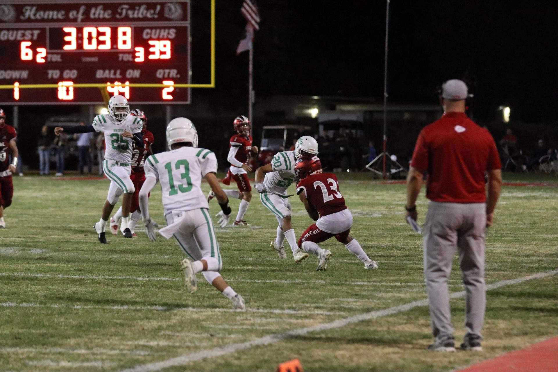 varsity football players in action against Riverdale