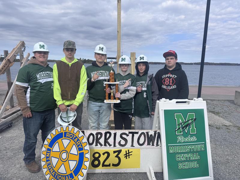 Students pose in front of sign