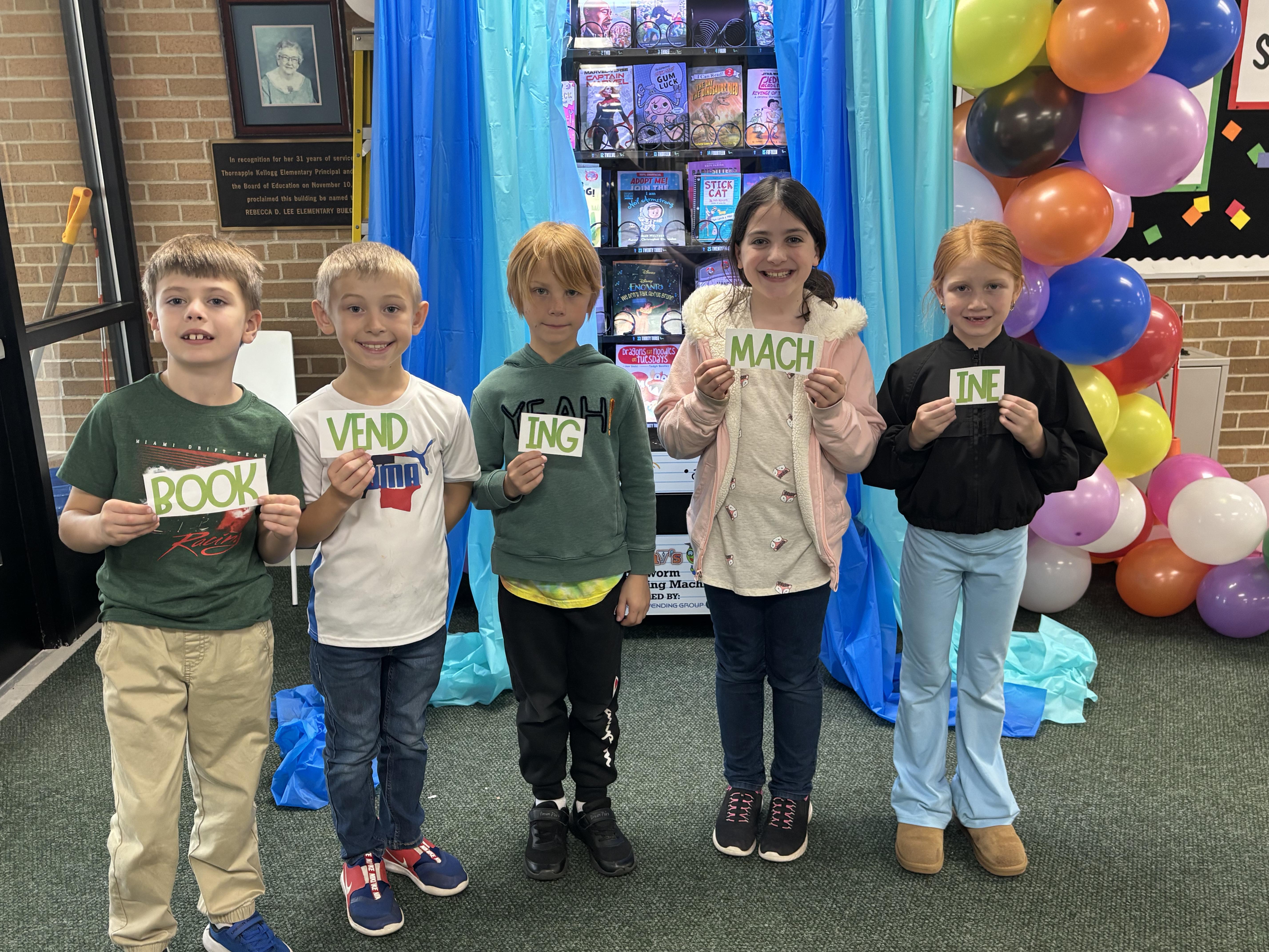 Students hold up their clues from the scavenger hunt.