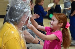 a student tossing a pie into a teacher's face