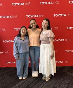 Three girls in front of red Toyota backdrop