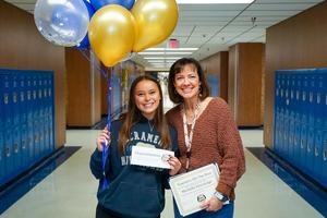 Michelle Discavage with Zoey Beckham holding balloons and certificate