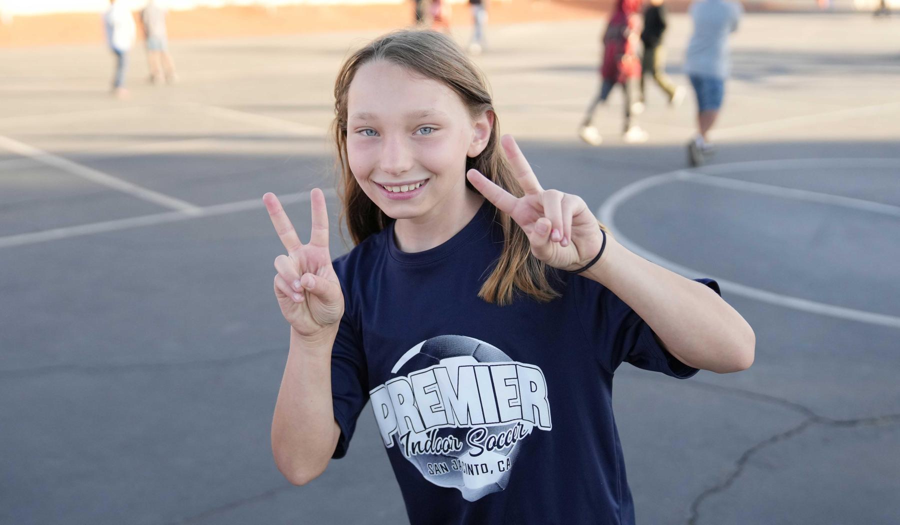 girl holding up peace signs with both hands!