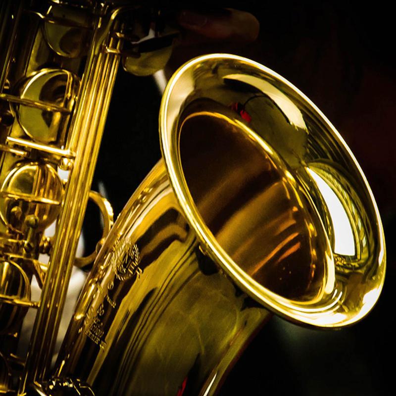 Close-up of a shiny saxophone bell reflecting light.