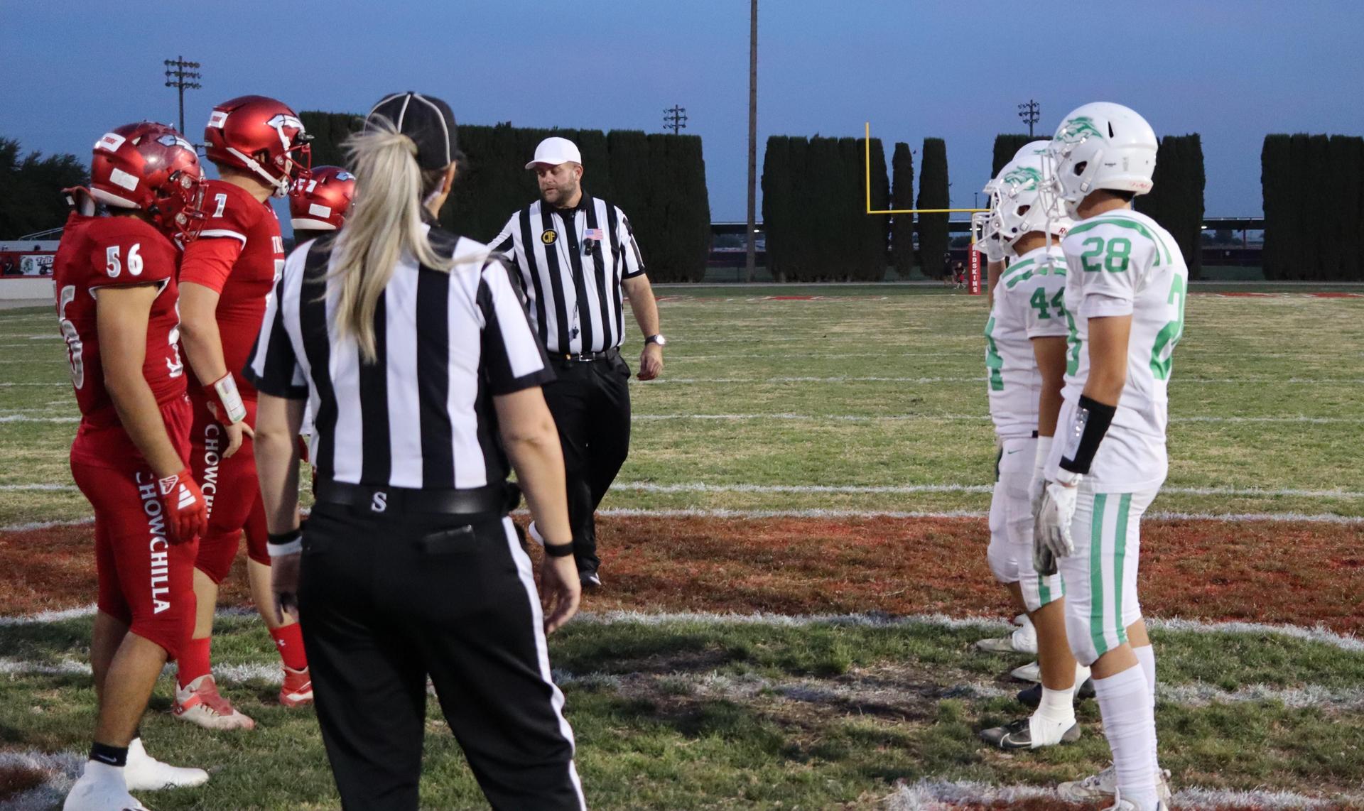 varsity football players in action against Riverdale