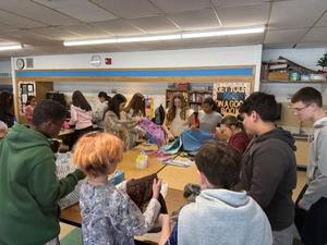 Students in a classroom organizing and folding fabric.