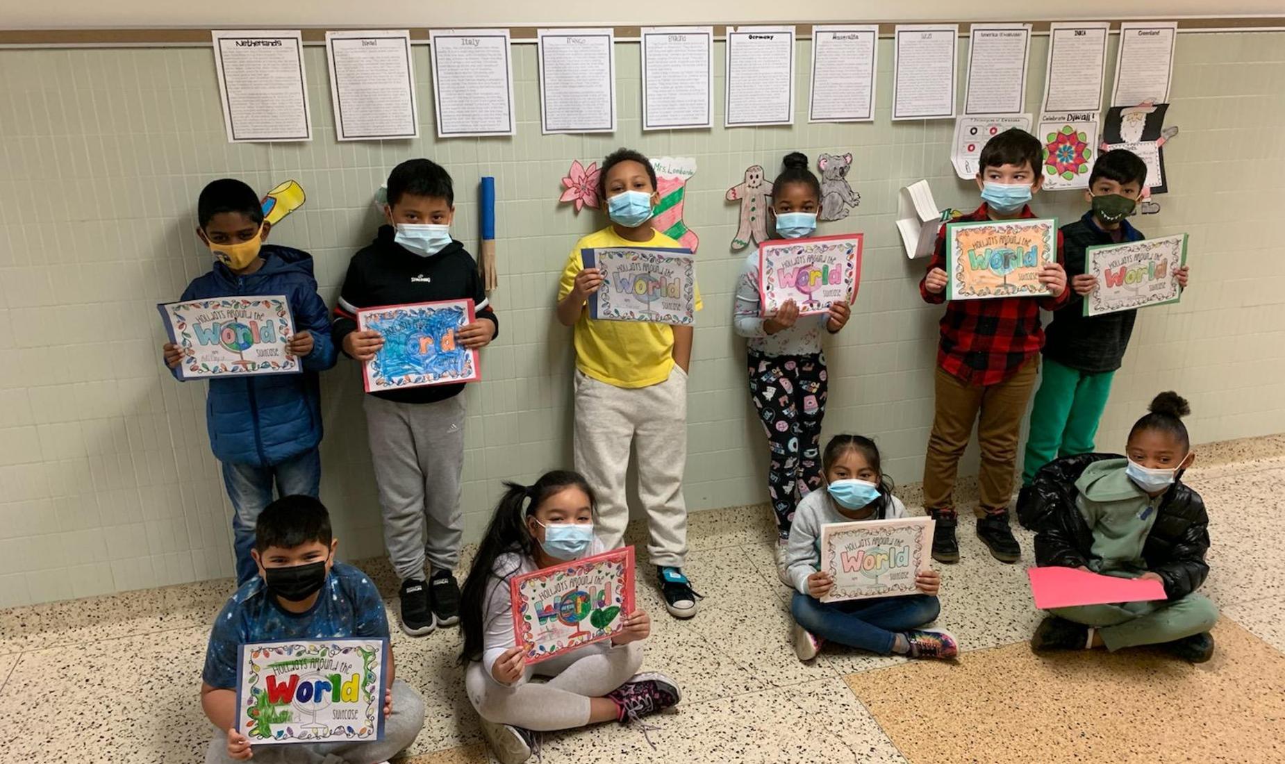 Young students holding signs about holidays around the world