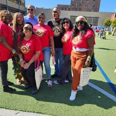 Group of people in red shirts posing together outdoors.
