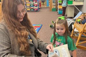 Mrs. Evans and Harper Kennedy read a book together