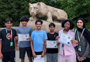 Image of 6 students standing by the Penn State Nittany Lion Statue