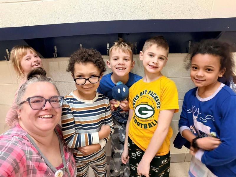 Group of children and an adult posing and smiling for a selfie.