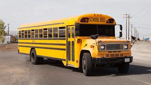 A yellow bus parked diagonally on the parking lot.
